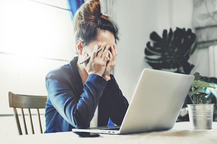 Businesswoman with their head in their hands in disappointment