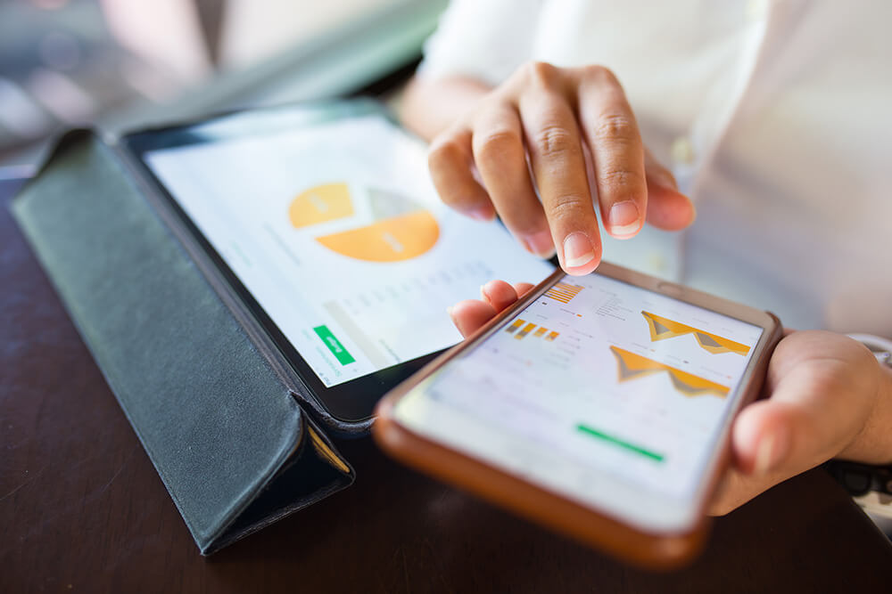 Saleswoman using a tablet and phone to monitor their sales process